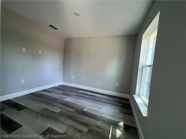 spare room with dark hardwood / wood-style flooring