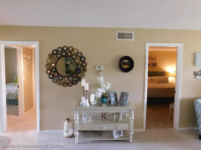 3513 Edgewater Dr, Sebring, FL 33872 - corridor featuring light colored carpet, visible vents, a textured ceiling, and baseboards