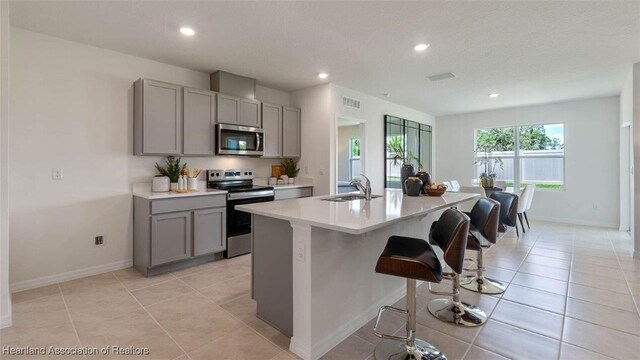 6824 Coconut Dr, Sebring, FL 33782 - kitchen featuring appliances with stainless steel finishes, gray cabinetry, a sink, recessed lighting, and light countertops
