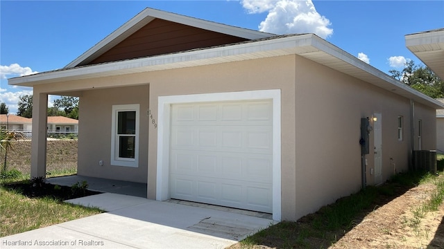 view of side of property featuring central AC unit, stucco siding, and fence