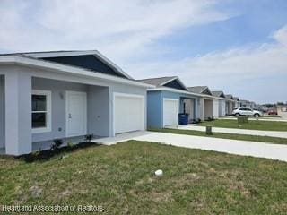 view of side of home featuring driveway, stucco siding, a garage, and a yard