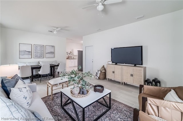 tiled living area featuring ceiling fan and visible vents