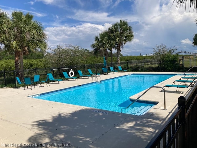 pool featuring fence and a patio