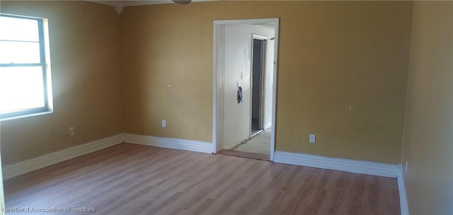 empty room featuring baseboards and wood finished floors