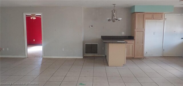 kitchen with dark countertops, light brown cabinets, visible vents, and light tile patterned flooring