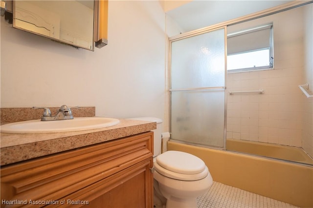 full bath featuring shower / bath combination with glass door, toilet, vanity, and tile patterned flooring