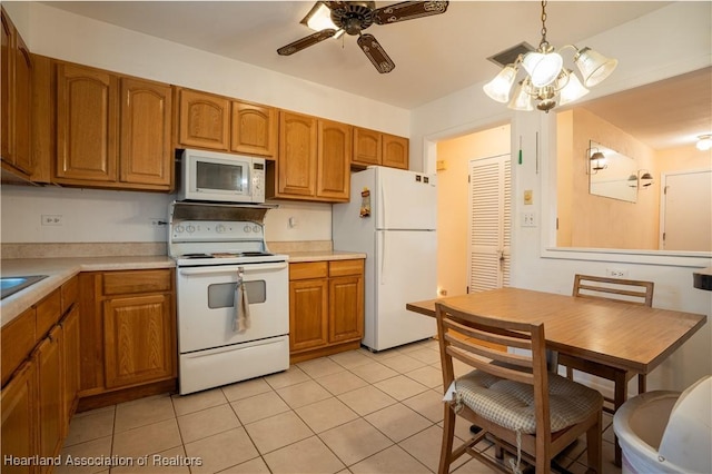 kitchen featuring white appliances, brown cabinetry, visible vents, and light countertops