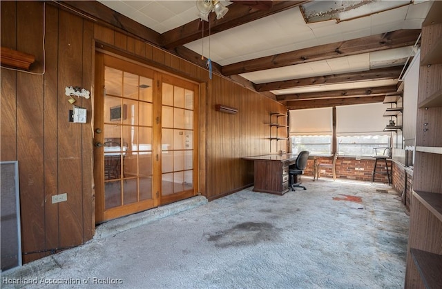 unfurnished office featuring beamed ceiling, carpet flooring, and wood walls