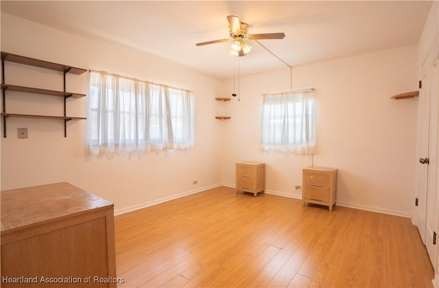 unfurnished bedroom with a ceiling fan, light wood-type flooring, and baseboards