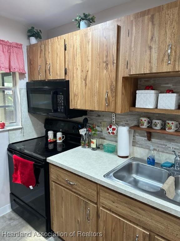 kitchen featuring decorative backsplash, sink, and black appliances