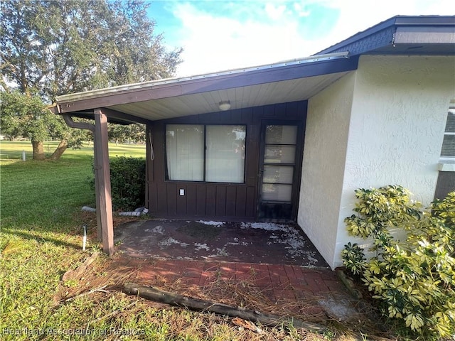 view of exterior entry with a yard