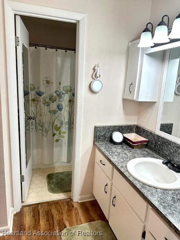 bathroom with vanity, wood-type flooring, and walk in shower