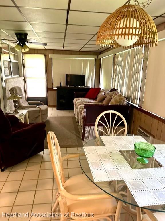 tiled dining room featuring a drop ceiling and ceiling fan