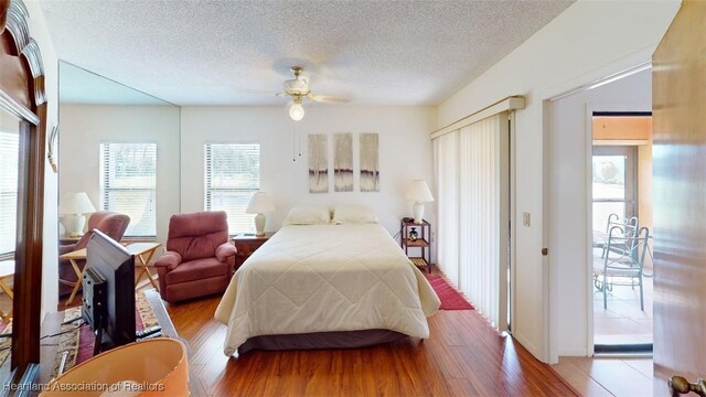 4701 Casablanca Cir Unit B5, Sebring, FL 33870 - bedroom featuring a textured ceiling, wood finished floors, ceiling fan, and access to exterior