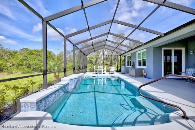 pool with a patio and glass enclosure