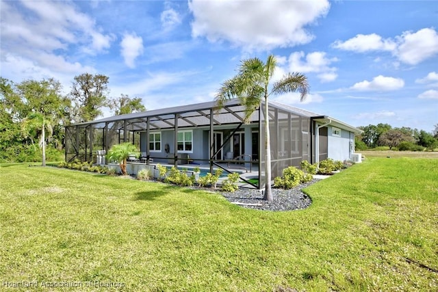 rear view of house with a patio, a yard, a swimming pool, and glass enclosure