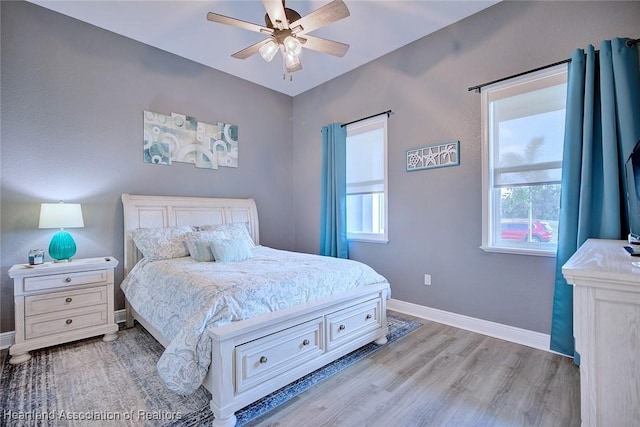 bedroom featuring baseboards, wood finished floors, and ceiling fan