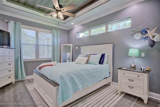 bedroom with baseboards, a ceiling fan, crown molding, and light wood-style flooring