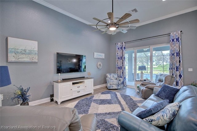 living room featuring ornamental molding, visible vents, light wood finished floors, and baseboards