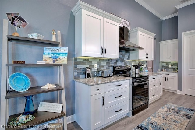 kitchen with range with electric stovetop, wall chimney exhaust hood, crown molding, and light wood-style floors