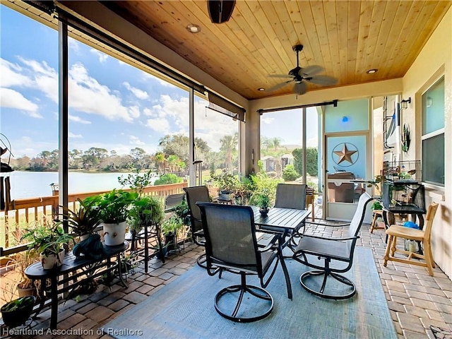 sunroom / solarium with ceiling fan, a water view, and wooden ceiling