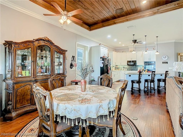 dining area featuring wooden ceiling, dark hardwood / wood-style floors, ceiling fan, and crown molding