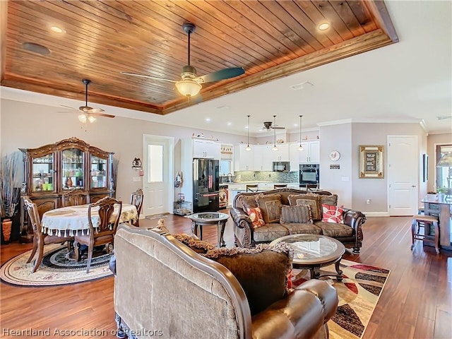 living room featuring dark hardwood / wood-style floors, wood ceiling, crown molding, and a tray ceiling