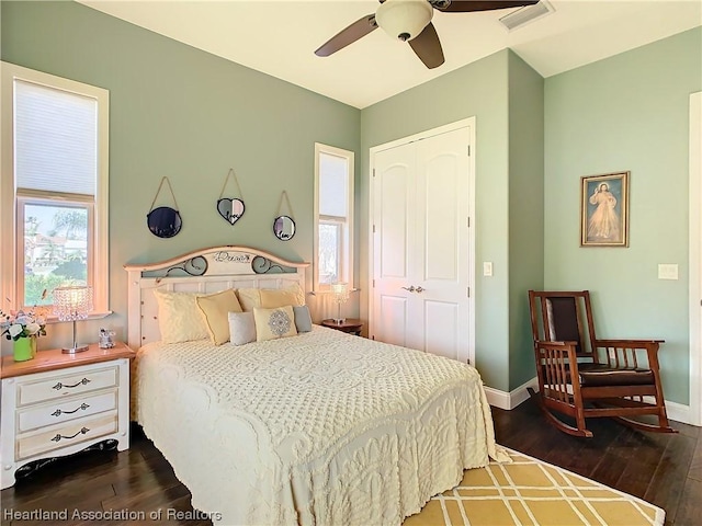 bedroom with a closet, dark wood-type flooring, and ceiling fan