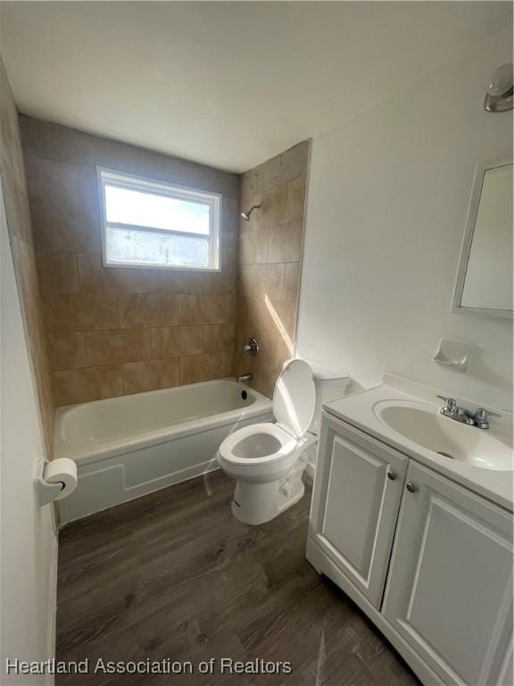 full bathroom featuring hardwood / wood-style flooring, vanity, toilet, and tiled shower / bath