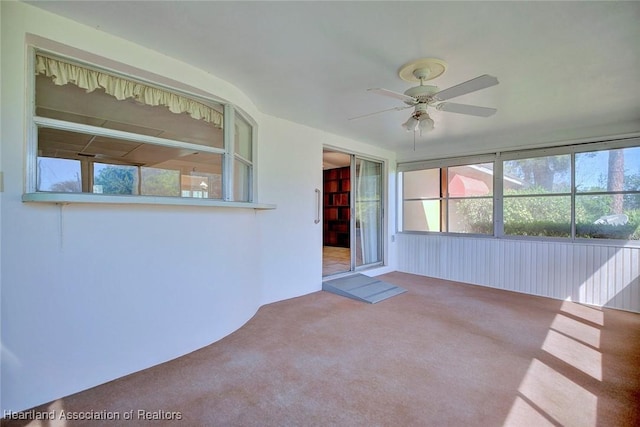 unfurnished sunroom featuring ceiling fan