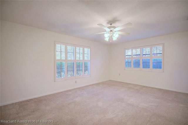 carpeted spare room with baseboards and ceiling fan