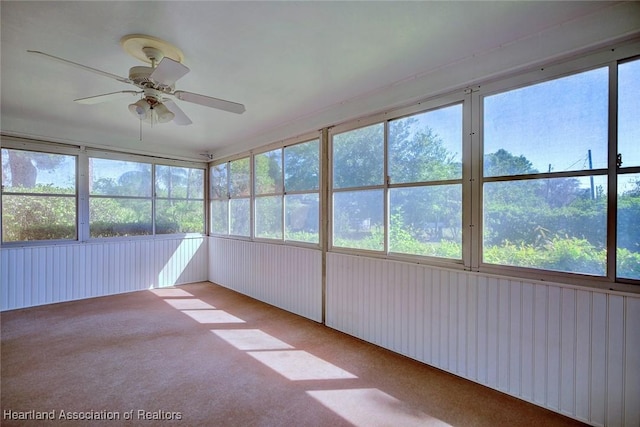 unfurnished sunroom featuring a ceiling fan