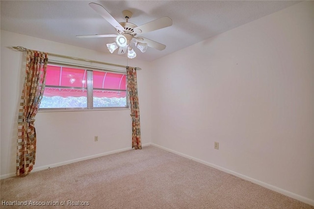 carpeted spare room with baseboards and ceiling fan