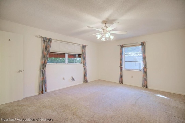 empty room featuring a textured ceiling, a ceiling fan, and carpet floors