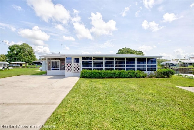 1644 Heron Dr S, Lorida, FL 33857 - view of front of house featuring a front lawn, a sunroom, and a water view