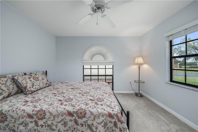 carpeted bedroom featuring ceiling fan and multiple windows