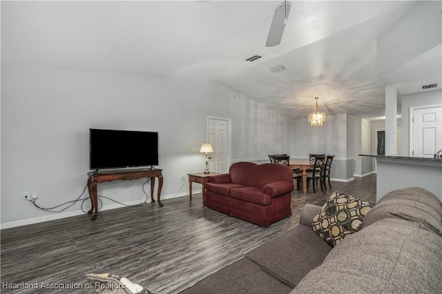 living room featuring lofted ceiling, dark hardwood / wood-style floors, and an inviting chandelier