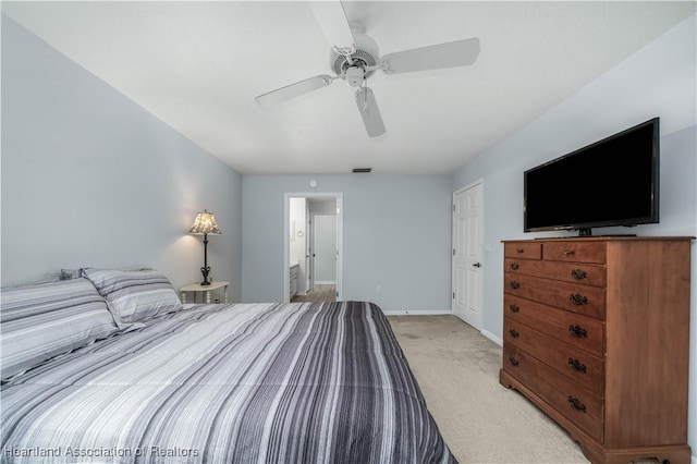 bedroom with light carpet, ensuite bath, and ceiling fan