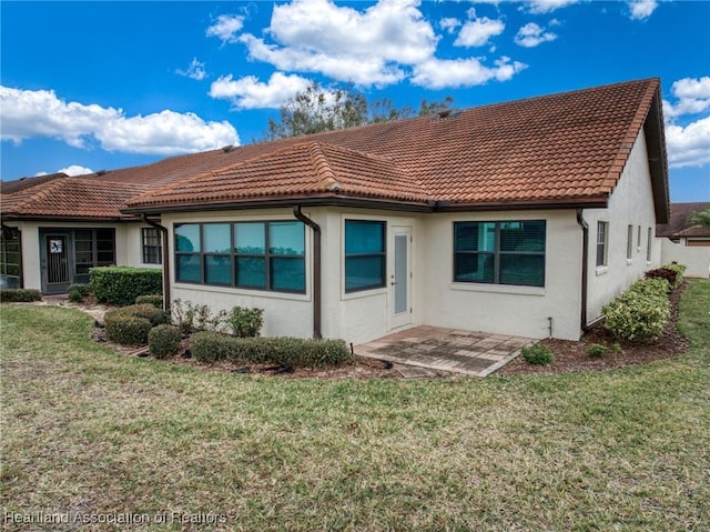 back of house with a patio area and a lawn