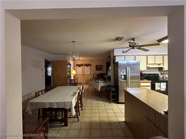 dining room with ceiling fan with notable chandelier, light tile patterned floors, and visible vents