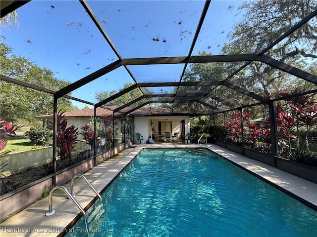 pool with a lanai and a patio area