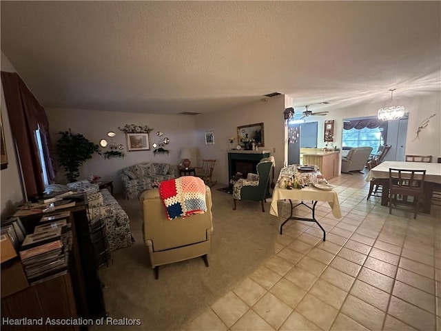 living area with visible vents, light tile patterned floors, a textured ceiling, ceiling fan with notable chandelier, and light carpet