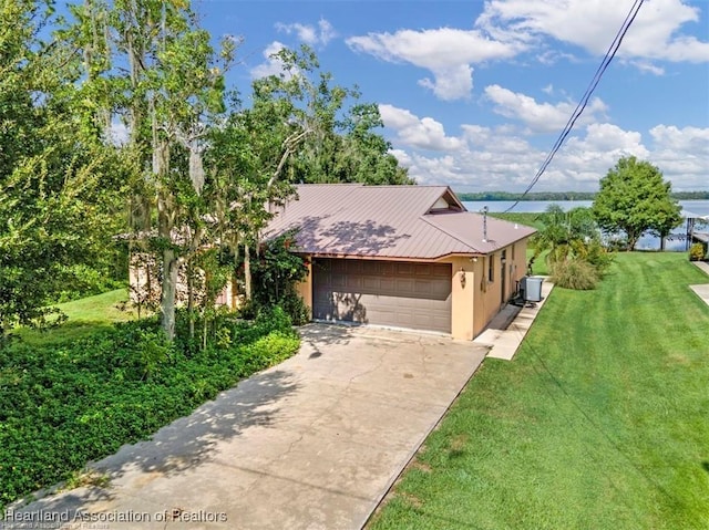 view of front of house featuring a front yard, a water view, a garage, and cooling unit