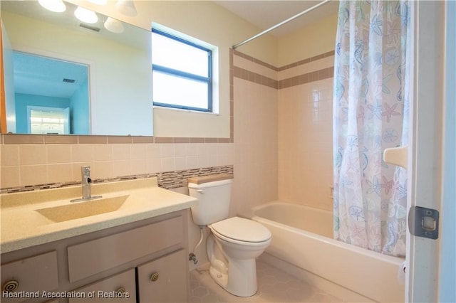 full bathroom featuring tile patterned floors, tile walls, decorative backsplash, vanity, and shower / tub combo