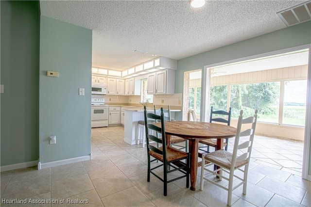 tiled dining space featuring a textured ceiling