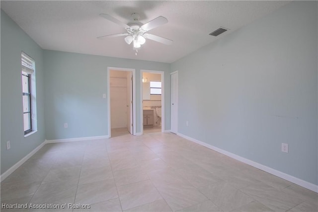 empty room with ceiling fan and a textured ceiling