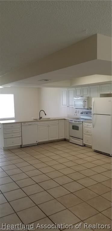 kitchen with white cabinetry, light tile patterned flooring, white appliances, and sink