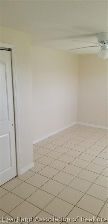 tiled spare room with ceiling fan