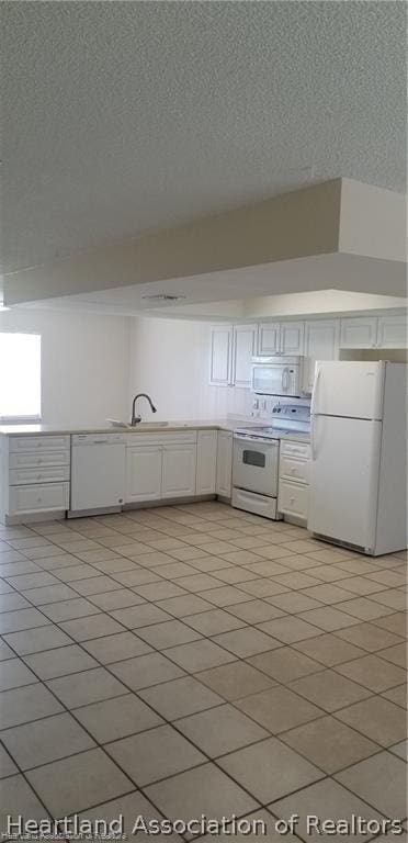 kitchen featuring white cabinetry, sink, a textured ceiling, white appliances, and light tile patterned flooring