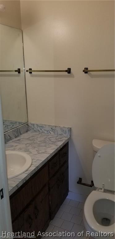 bathroom featuring tile patterned flooring, vanity, and toilet